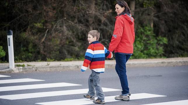 Mother and son crossing the street on the crosswalk